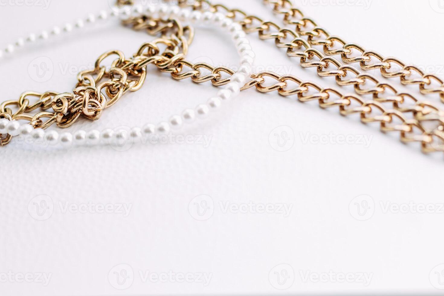 A necklace of white beads with chains of jewelry on a white aesthetic background. photo
