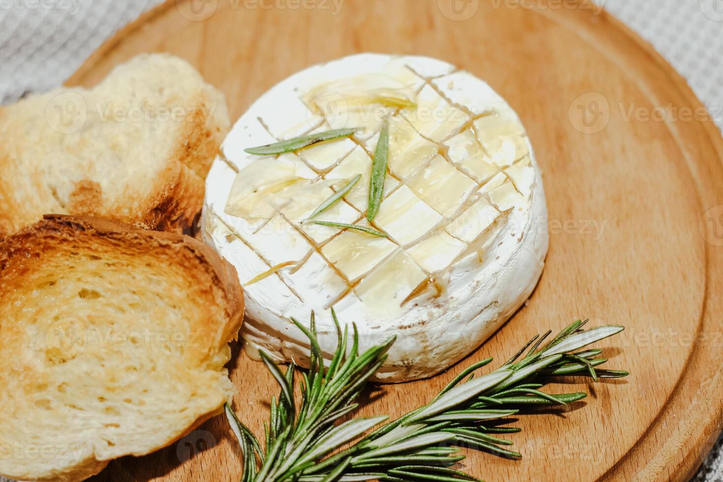 White baguette cut into pieces with olive oil and Camembert cheese on the table. photo