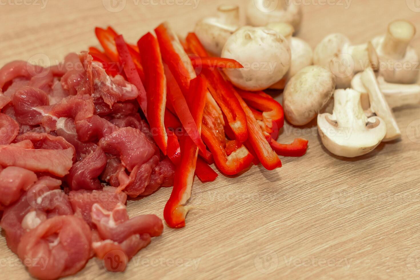 Sliced meat, champignons and red pepper on a board. photo