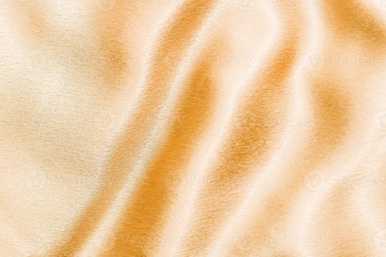 Yellow shiny texture of silk satin satin with folds. photo