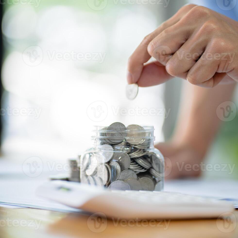 Saving money. Businessman Accountant verify growing business and saving money stacking coins with calculator. Accountancy Concept. photo