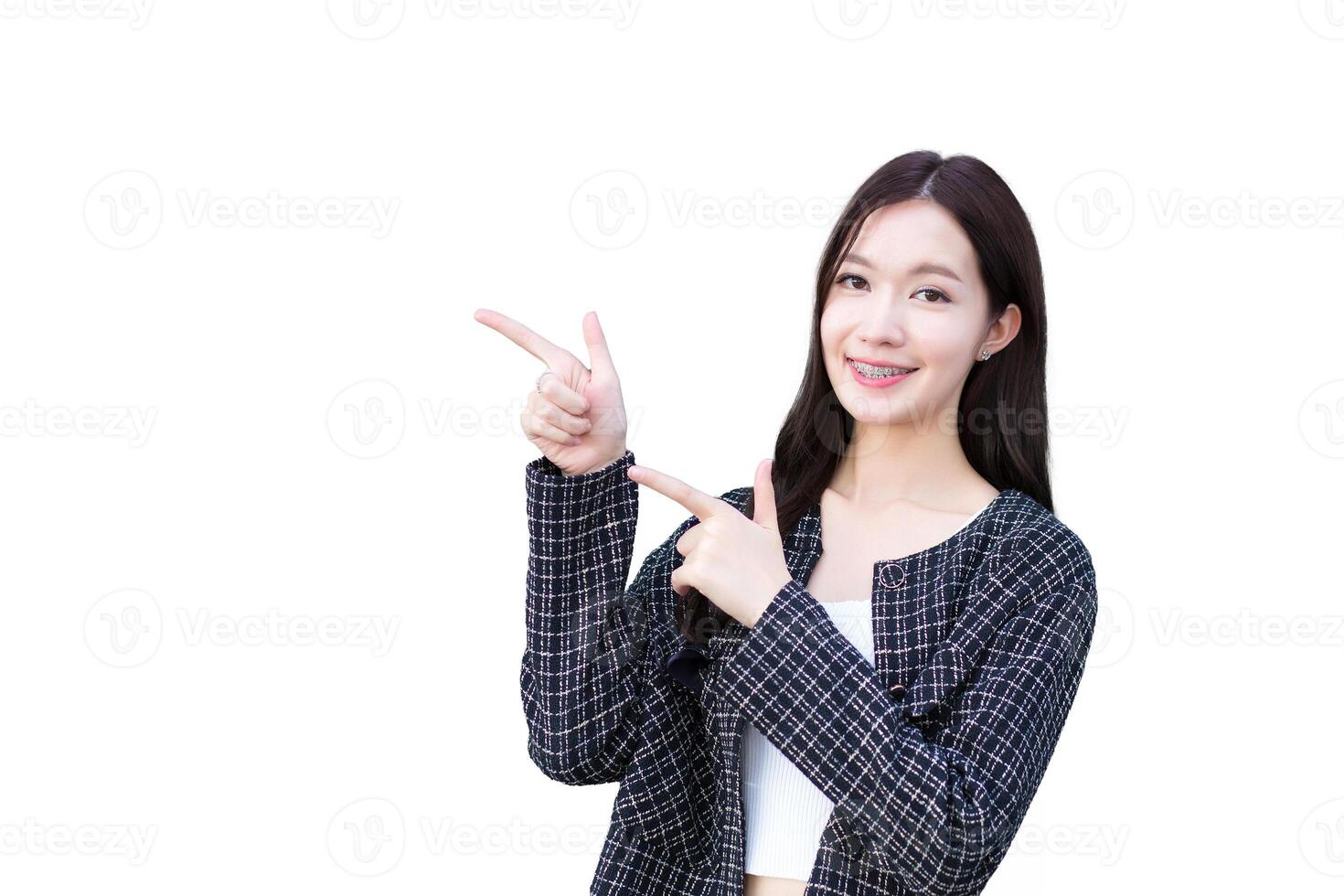 Professional young asian working woman who wears black suit with braces on teeth is pointing hand to present something while isolated white background. photo