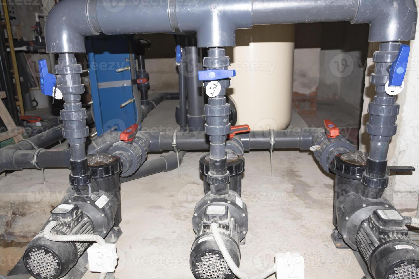 A room for dosing chemicals of chlorine and acid when feeding into the pool. Water circulation system in the pumping room. photo