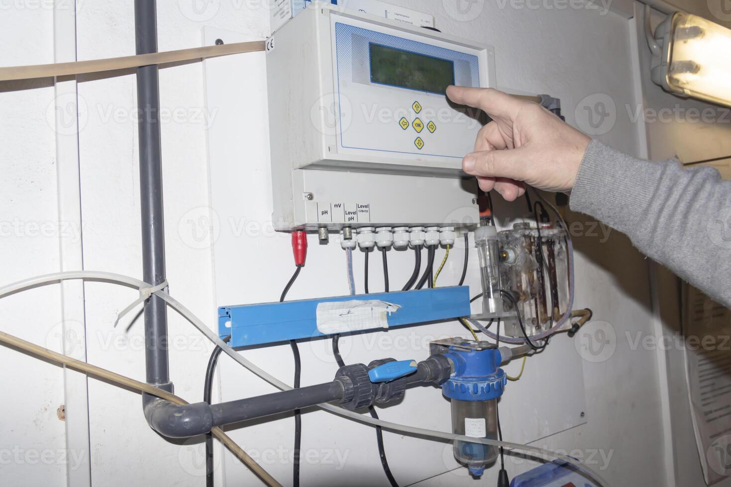 A room for dosing chemicals of chlorine and acid when feeding into the pool. Water circulation system in the pumping room. photo