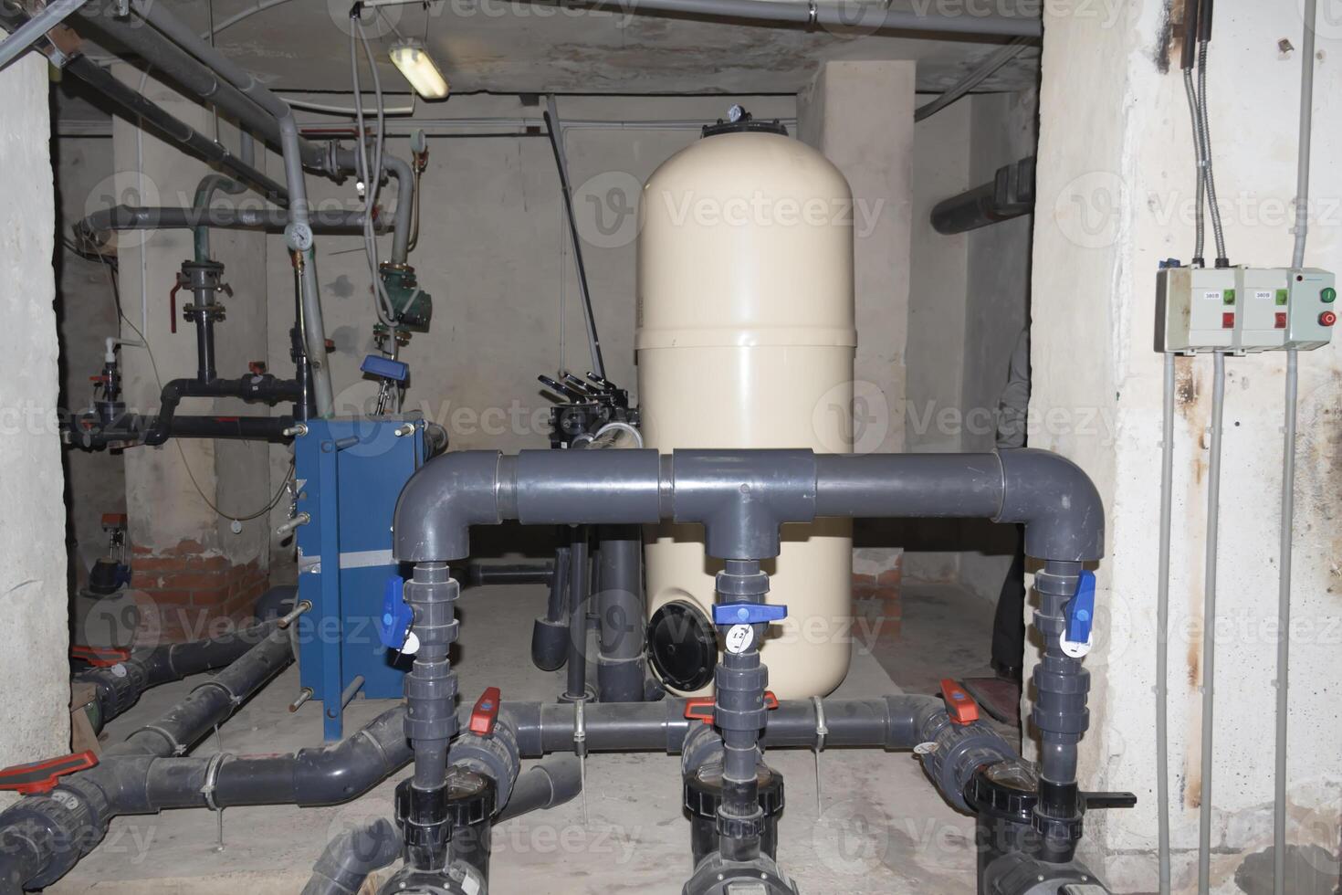 A room for dosing chemicals of chlorine and acid when feeding into the pool. Water circulation system in the pumping room. photo
