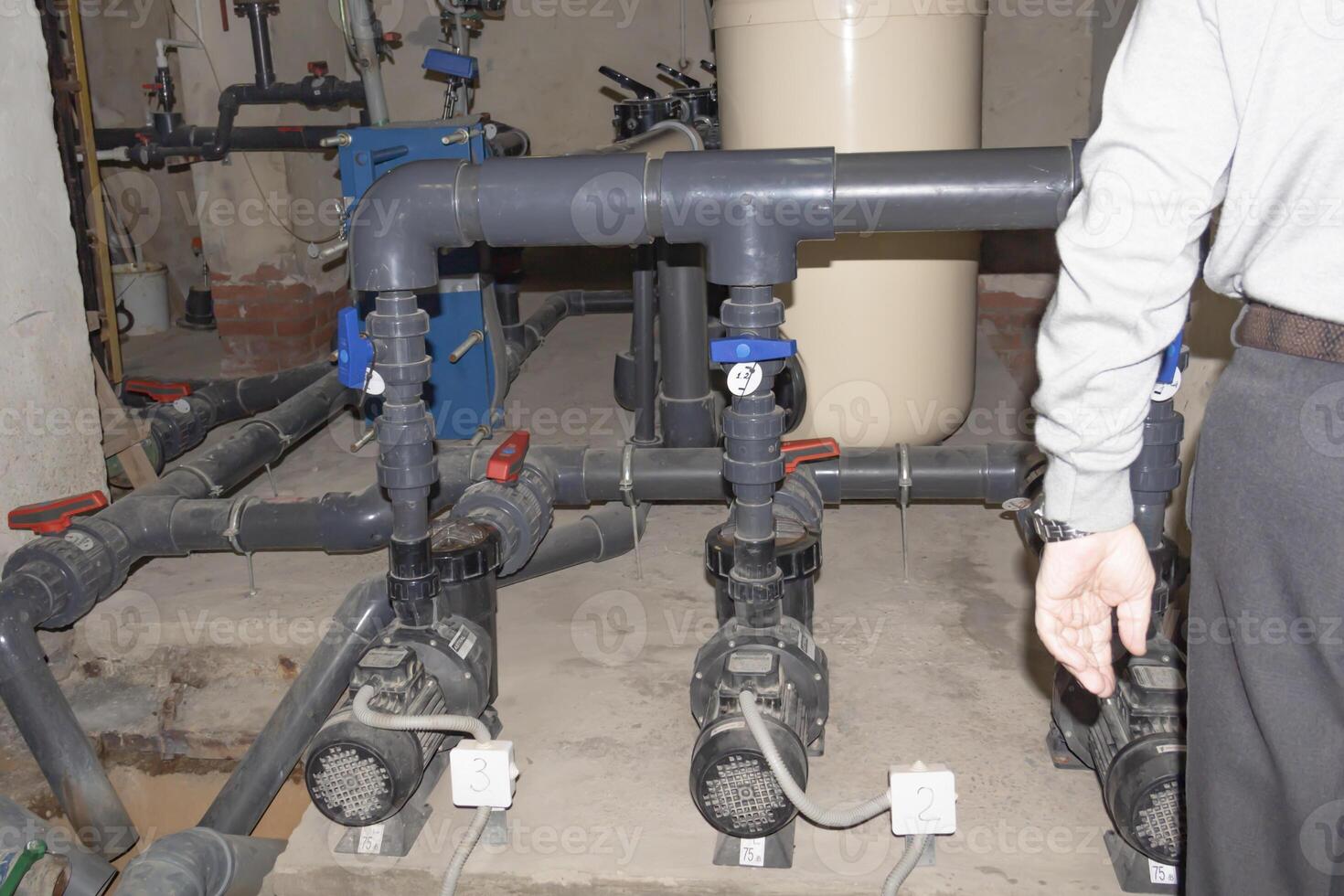 A room for dosing chemicals of chlorine and acid when feeding into the pool. Water circulation system in the pumping room. photo