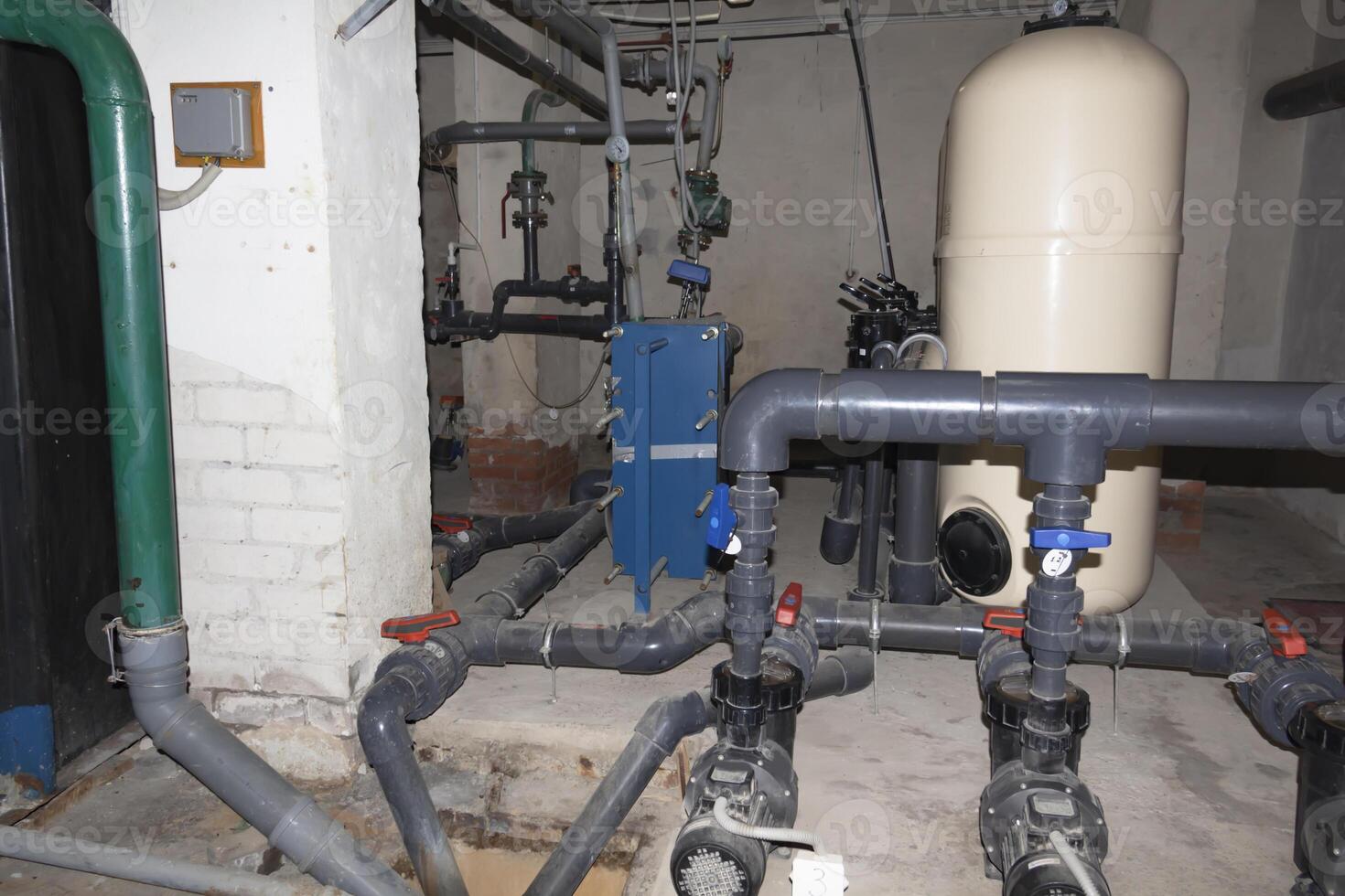 A room for dosing chemicals of chlorine and acid when feeding into the pool. Water circulation system in the pumping room. photo