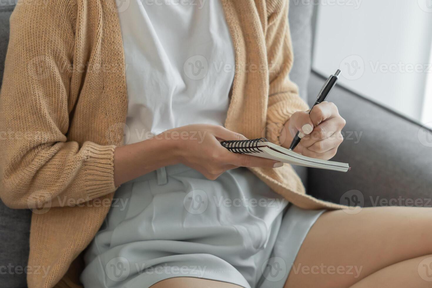 woman working from home taking reading and writing notes in note photo