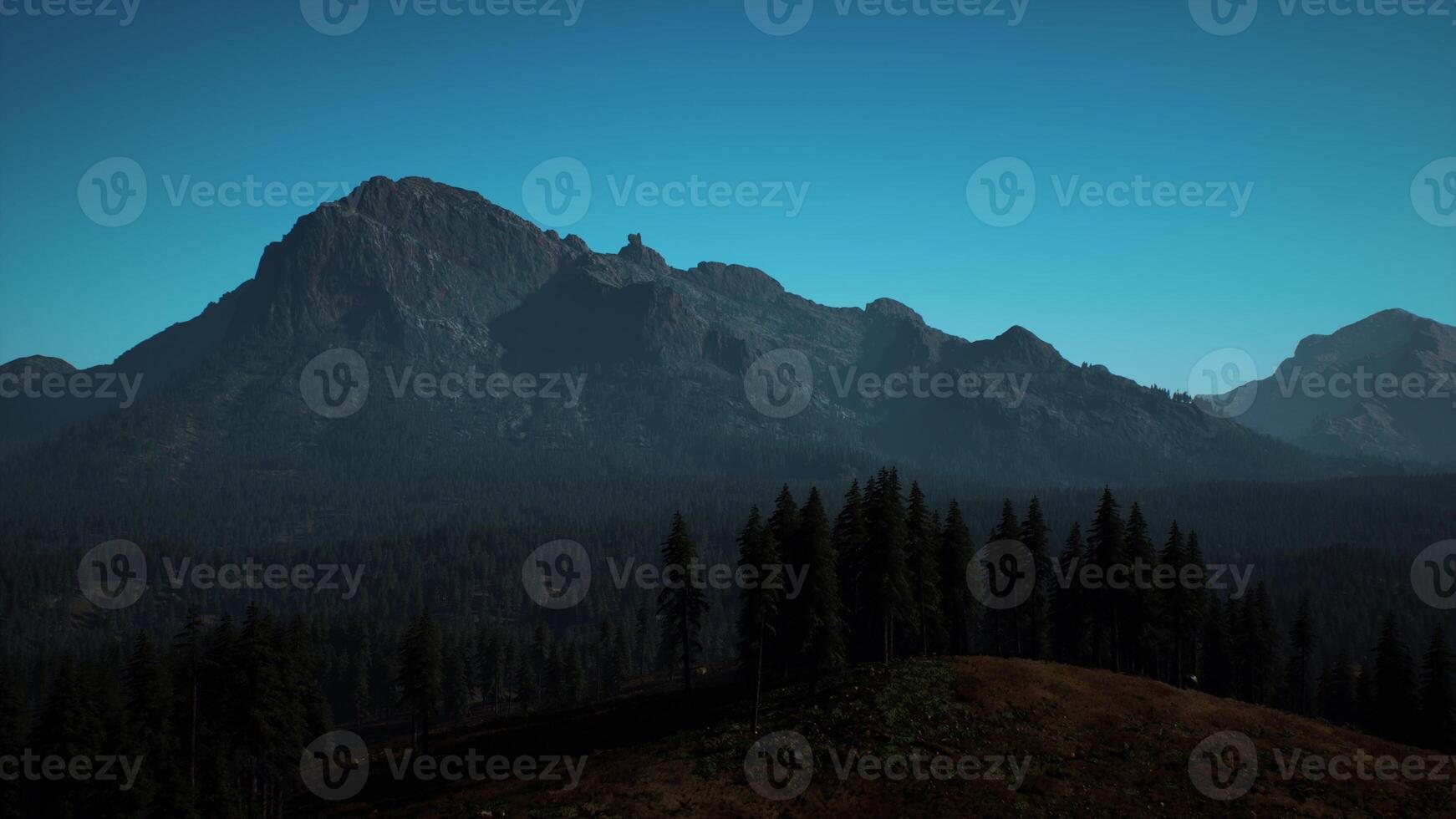 A view of a mountain range with trees in the foreground photo