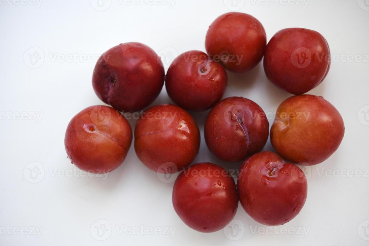 Red plums on a white background. Plums on a plate. Washed fruits. photo