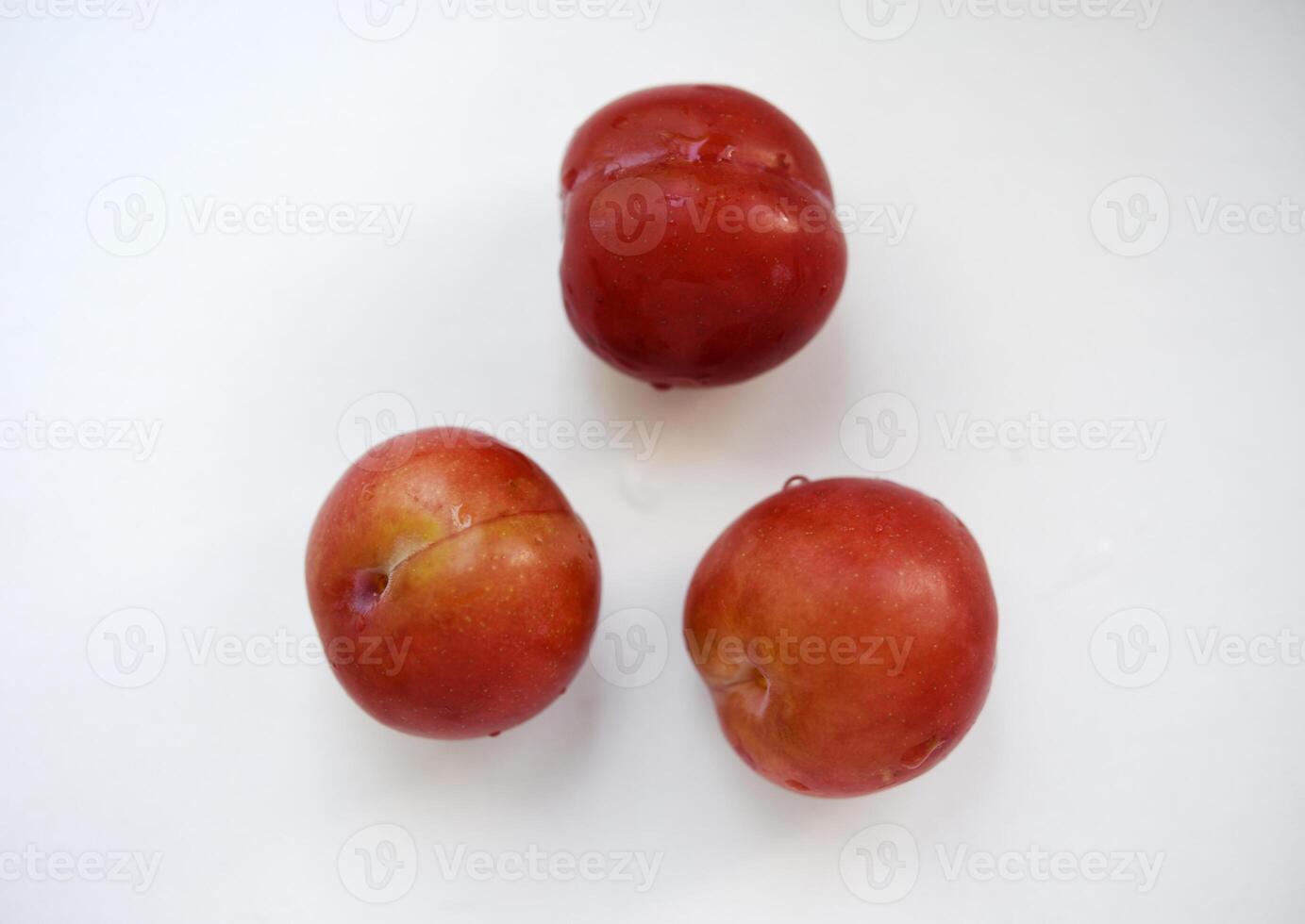 Red plums on a white background. Plums on a plate. Washed fruits. photo