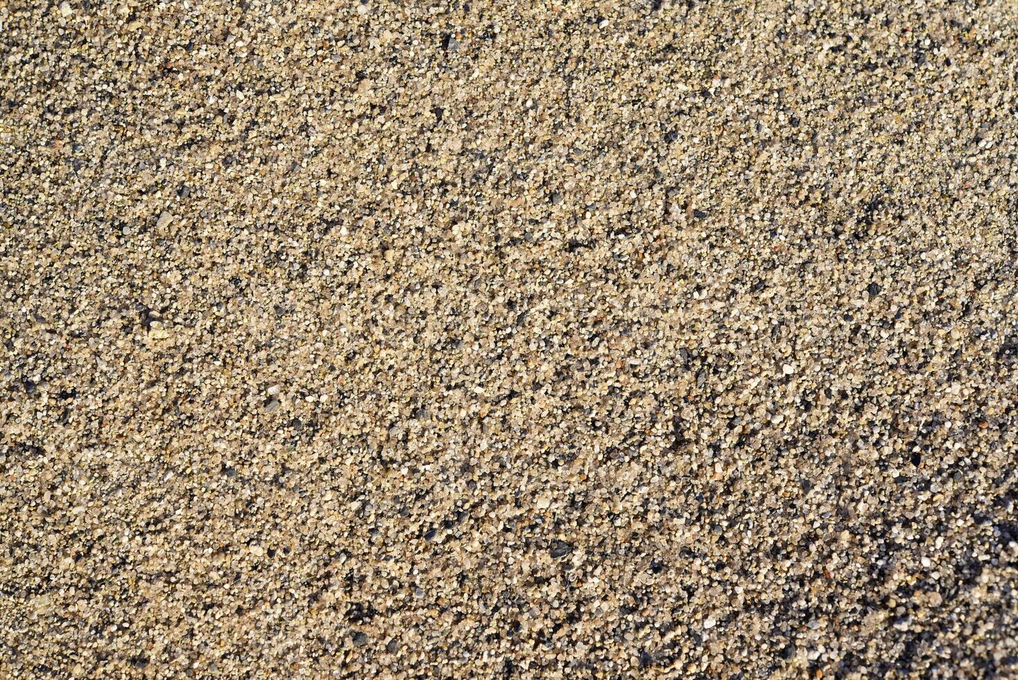 The river sand is coarse-grained. Small pebbles of river sand. Macrophotography of sand. photo