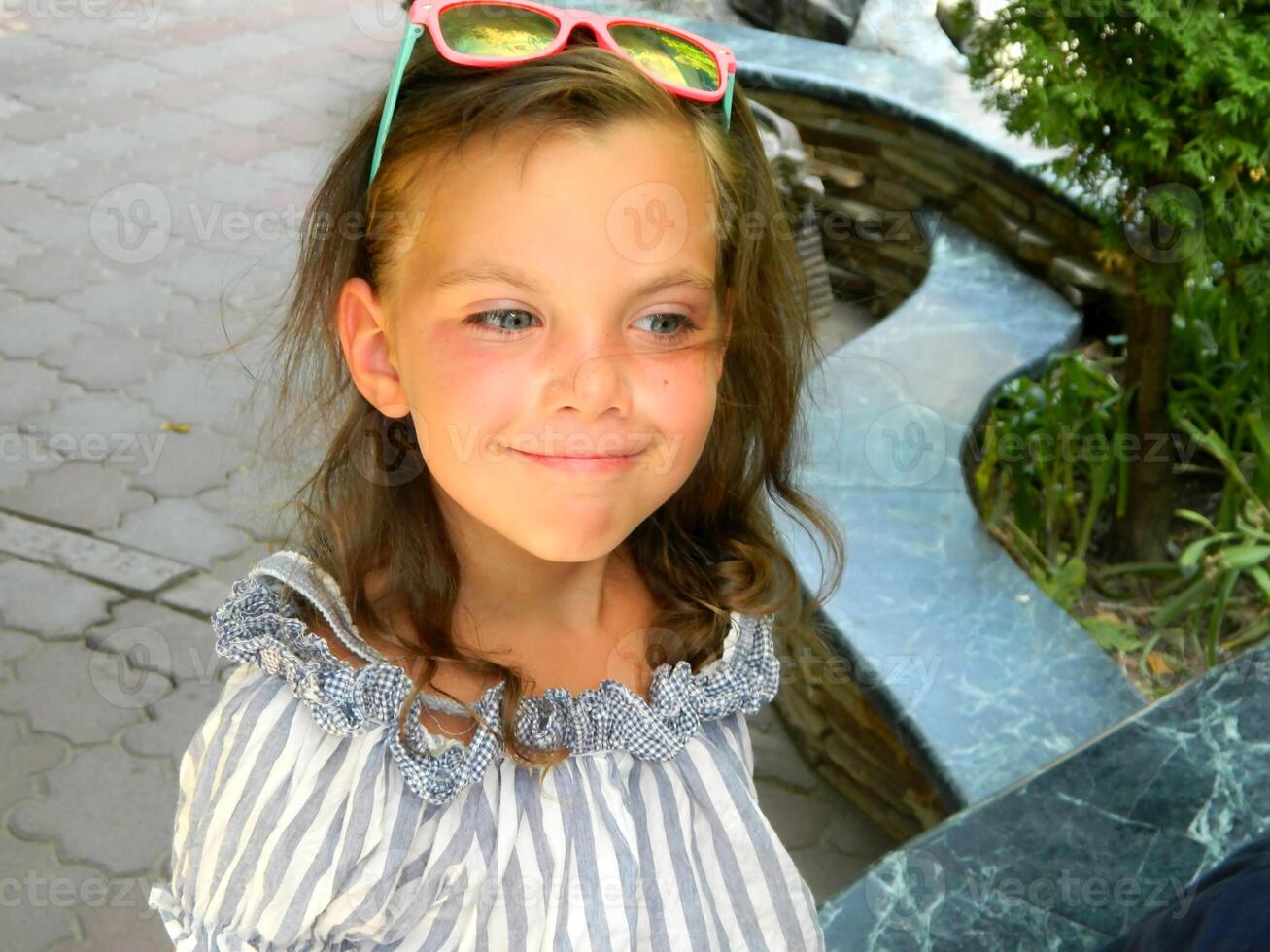 Little girl in the garden. Beautiful flowers roses. photo