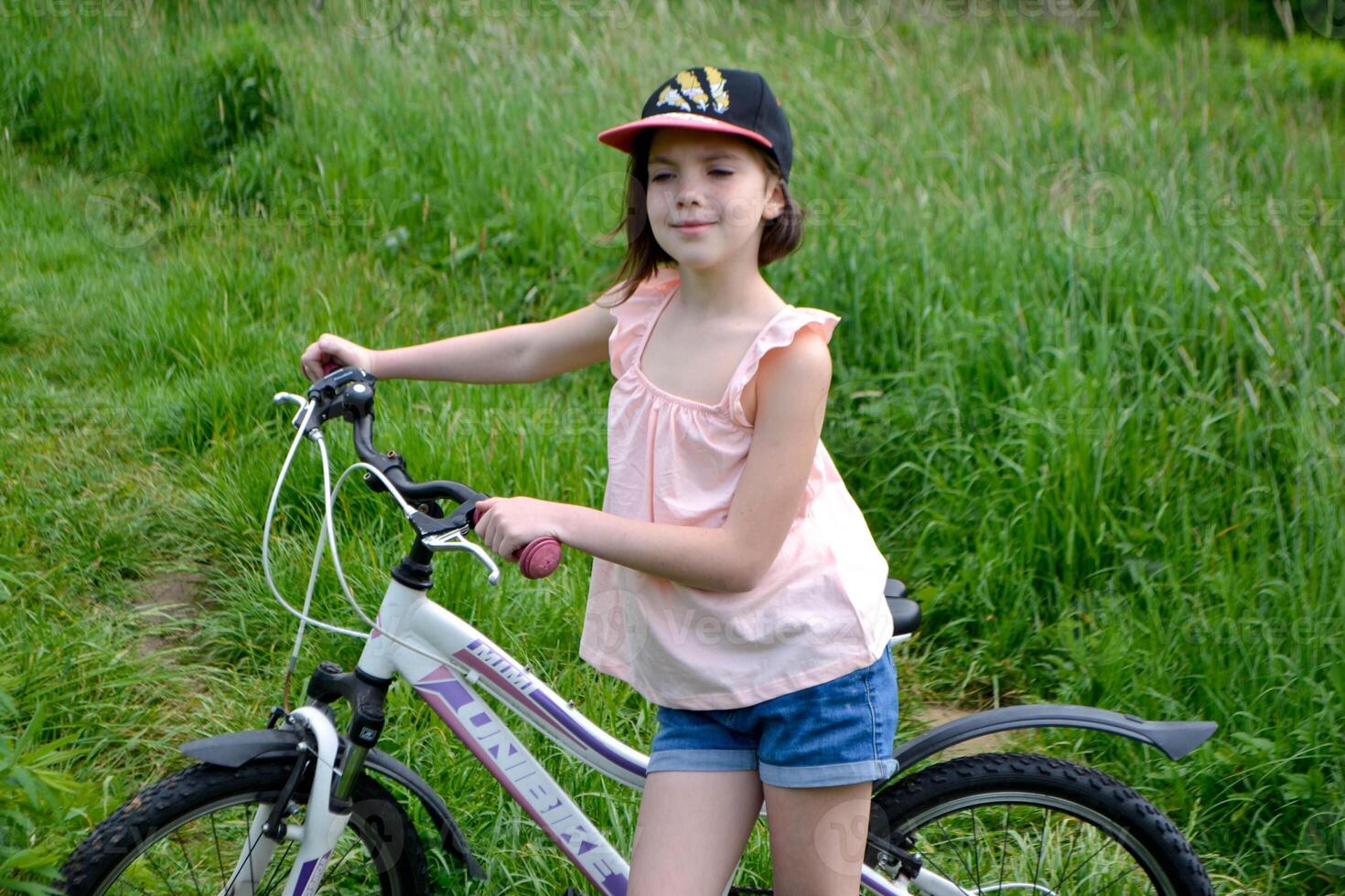 Young girl cyclist enjoy the beautiful sunrise on summer forest trail photo