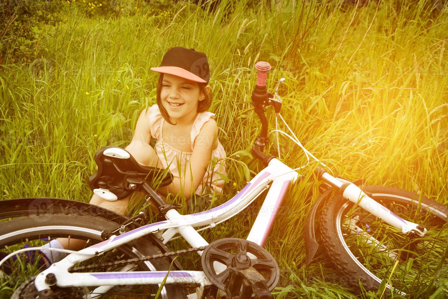 Young girl cyclist enjoy the beautiful sunrise on summer forest trail photo