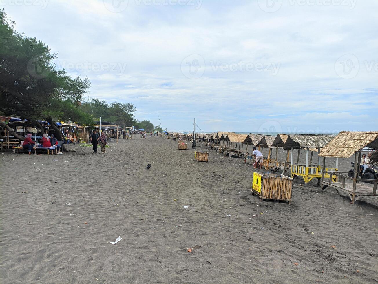 PURWOREJO CENTRAL JAV INDONESIA APRIL 17 2024 conditions around Jatimalang beach with many visitors and huts or huts neatly lined up photo