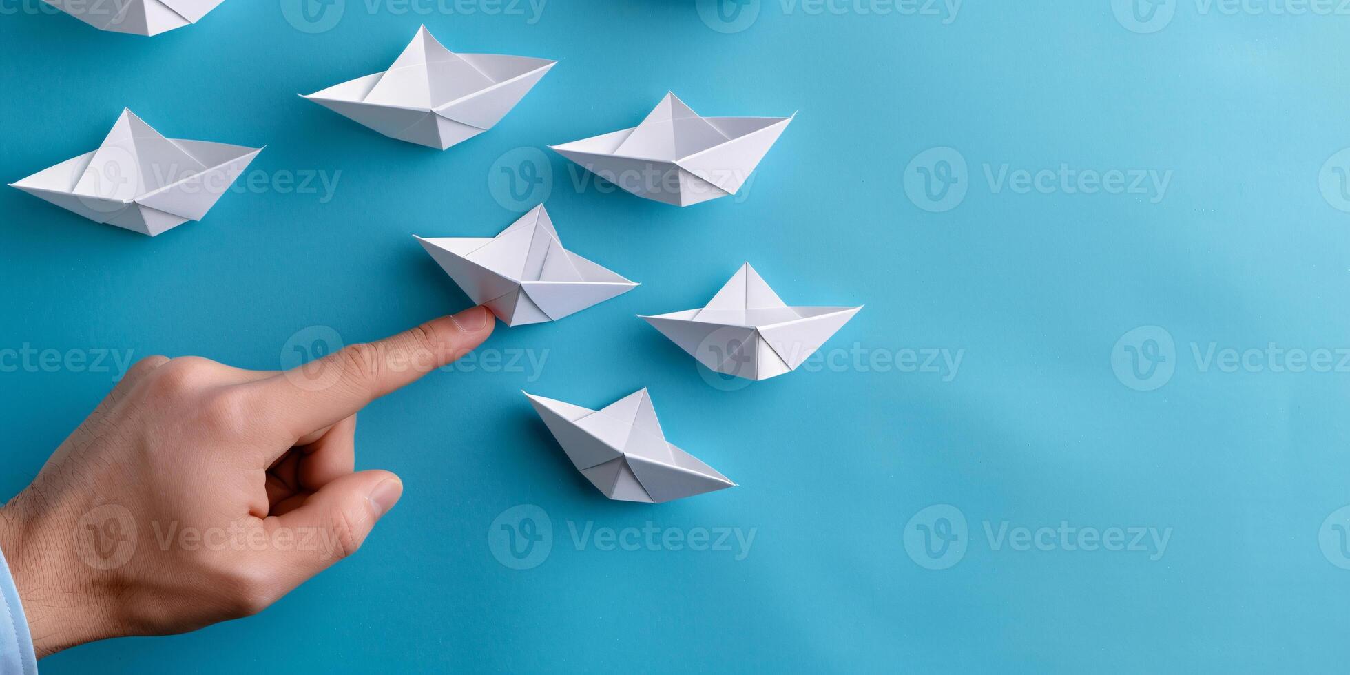 A hand holding paper ships symbolize sending a message or business ideas and flag ship photo