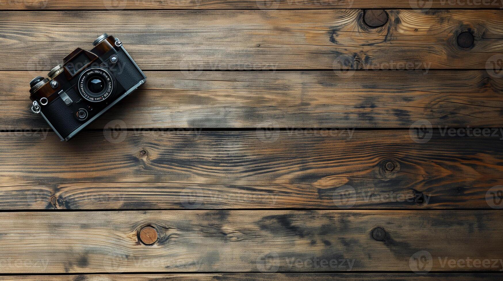 Camera lying on a wooden plain surface on beautiful background, top view photo