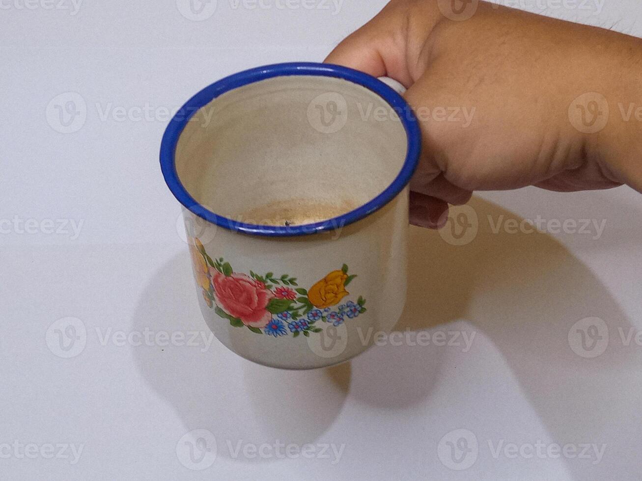 A hand holding vintage coffee mug on a white background photo