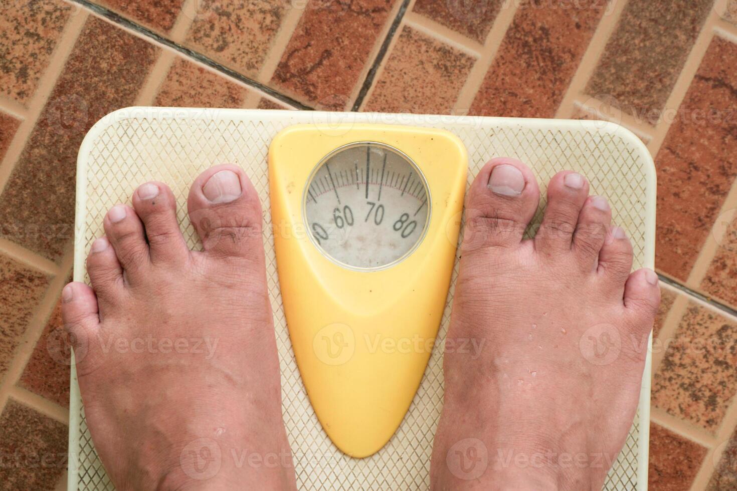 Close up of man legs standing on weight scales. Standing on floor scale at home. A man checking his weight photo