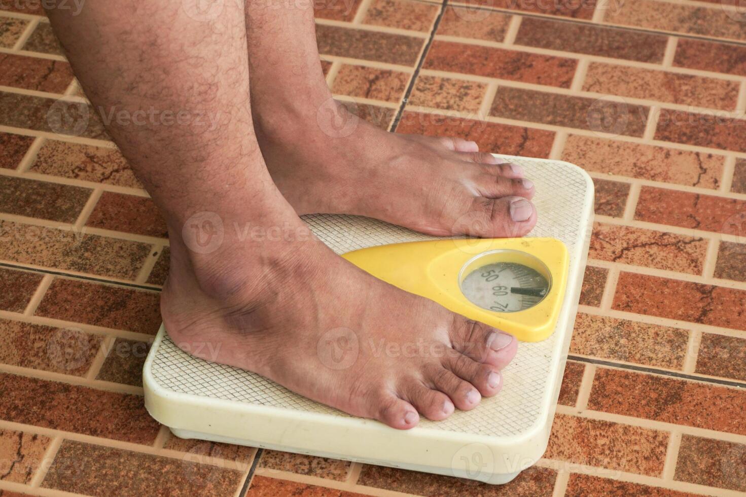 Close up of man legs standing on weight scales. Standing on floor scale at home. A man checking his weight photo