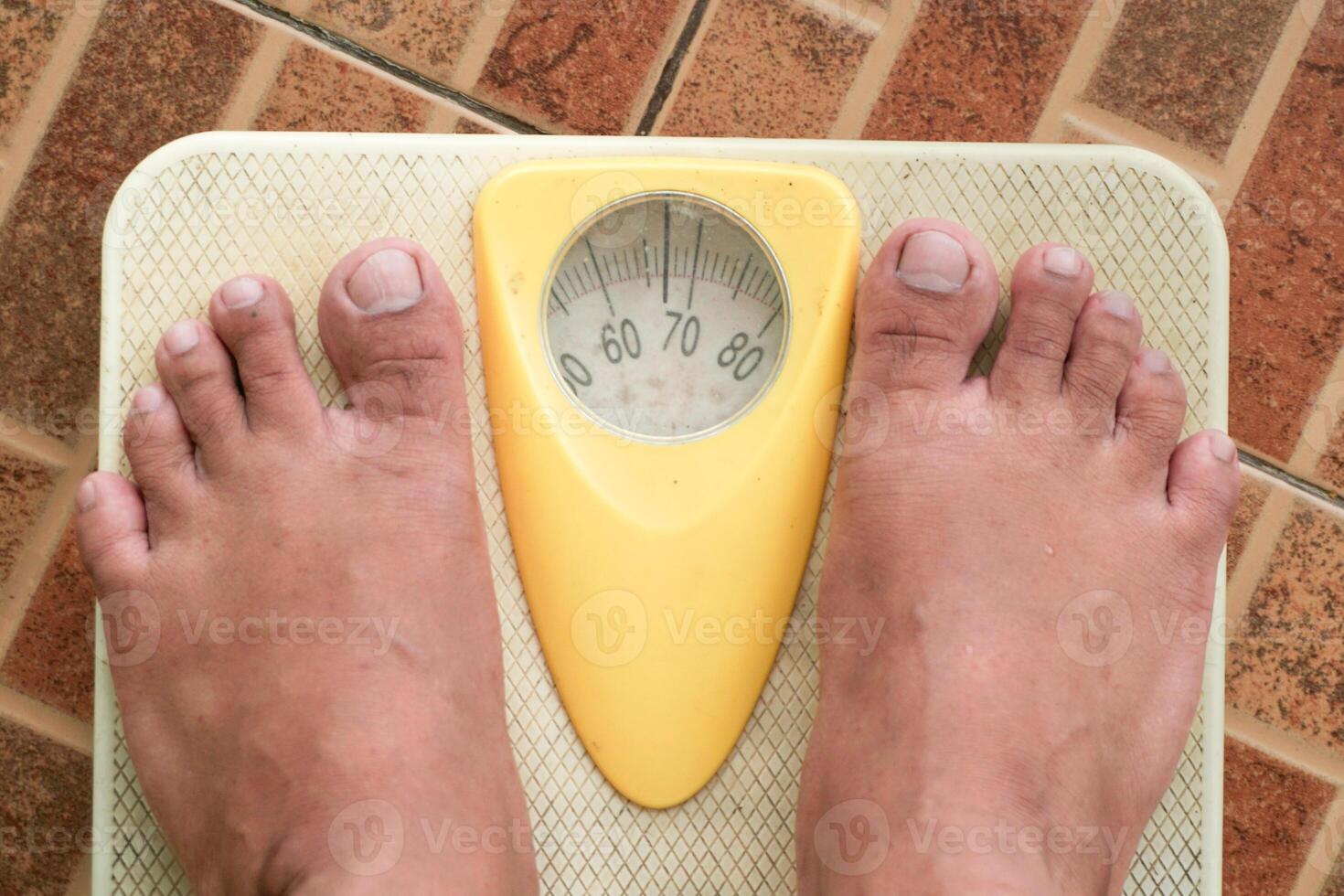 Close up of man legs standing on weight scales. Standing on floor scale at home. A man checking his weight photo