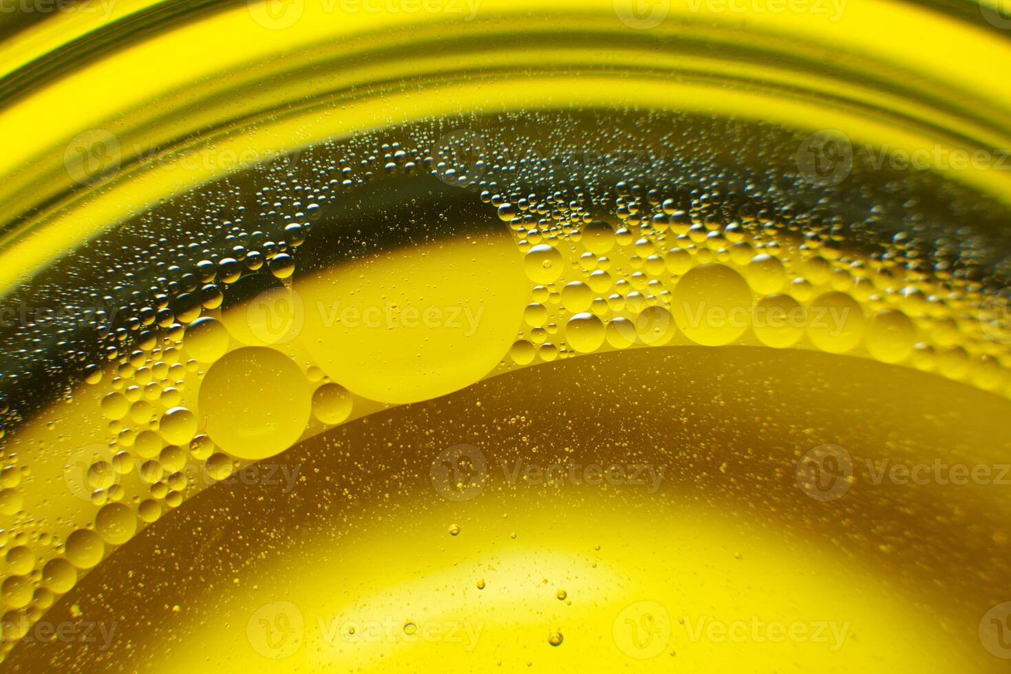 Yellow oil bubbles on water, cooking oil background. photo