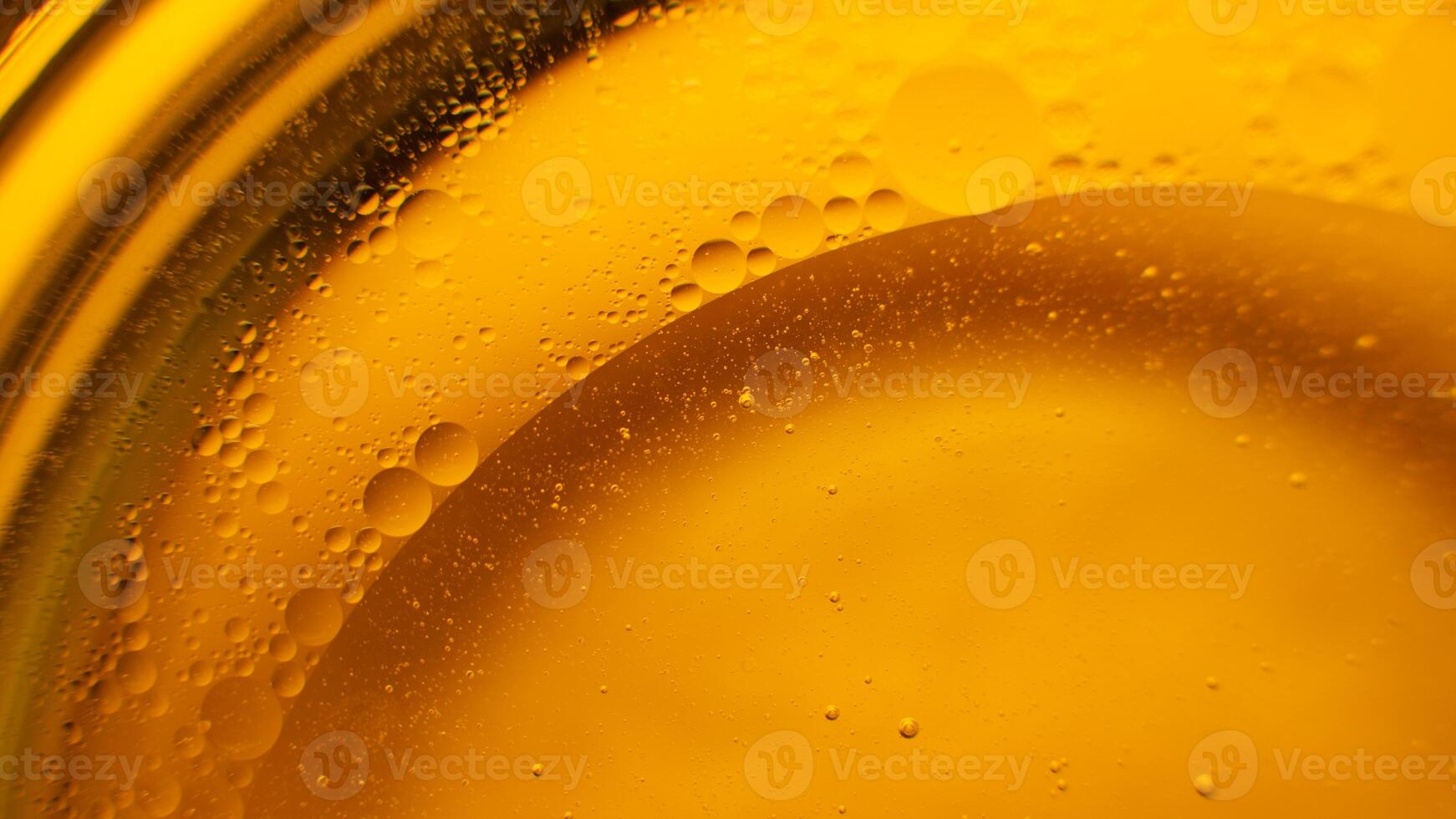 Yellow oil bubbles on water, cooking oil background. photo