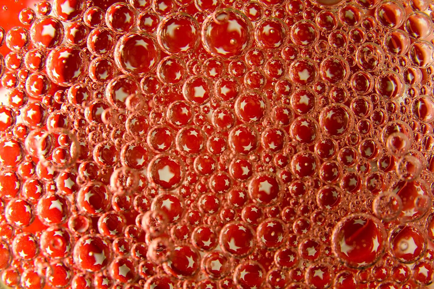 Red bubbles and drops of water on a white background star from an American flag. photo