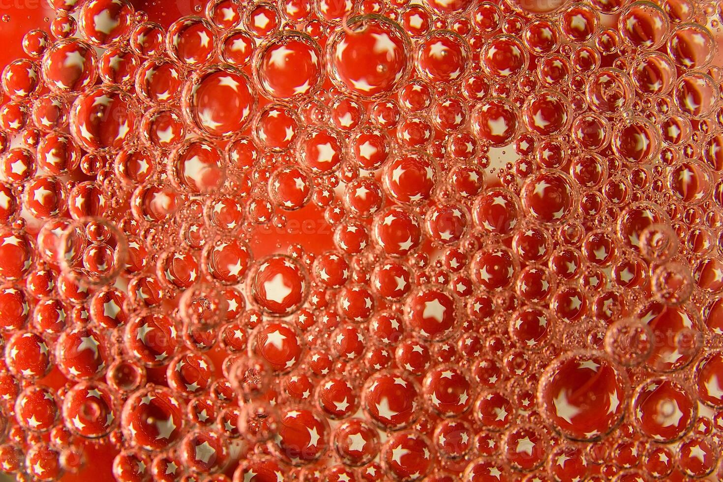 Red bubbles and drops of water on a white background star from an American flag. photo