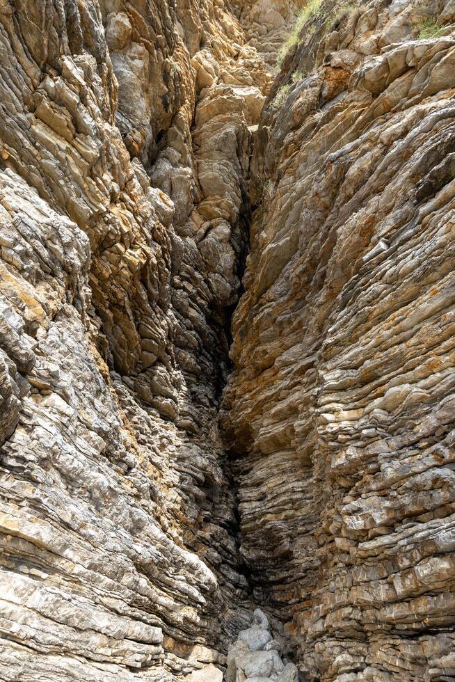 Detailed view of a narrow rock crevice in a cliff. background, texture. High quality photo