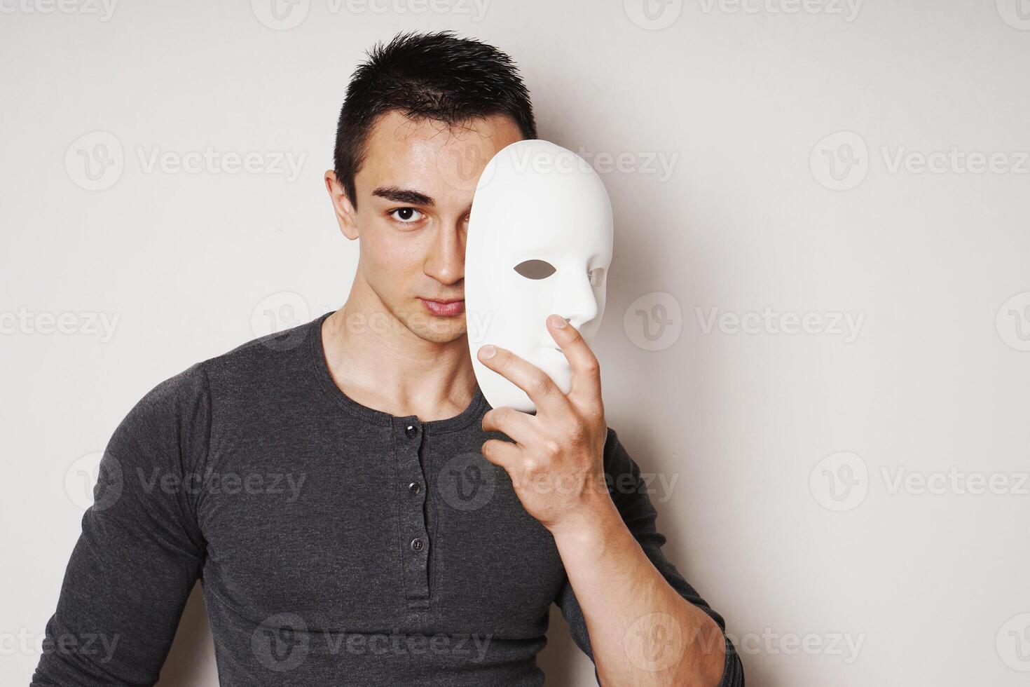 young man taking off white mask revealing face and identity photo