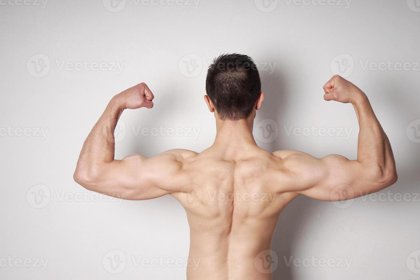 man flexing biceps and back muscles photo