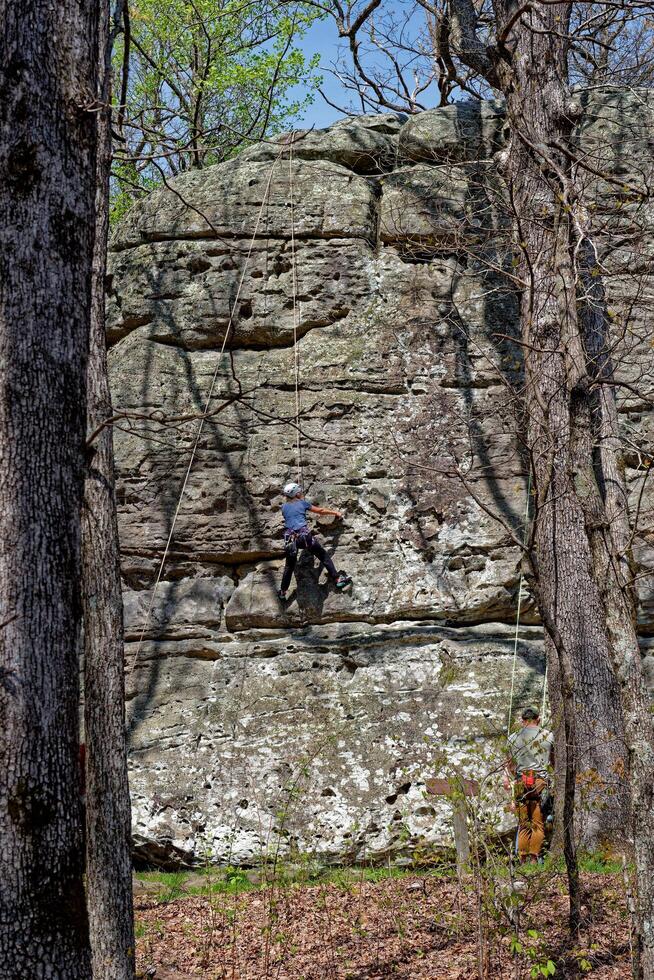 Climbing up a boulder vertically photo
