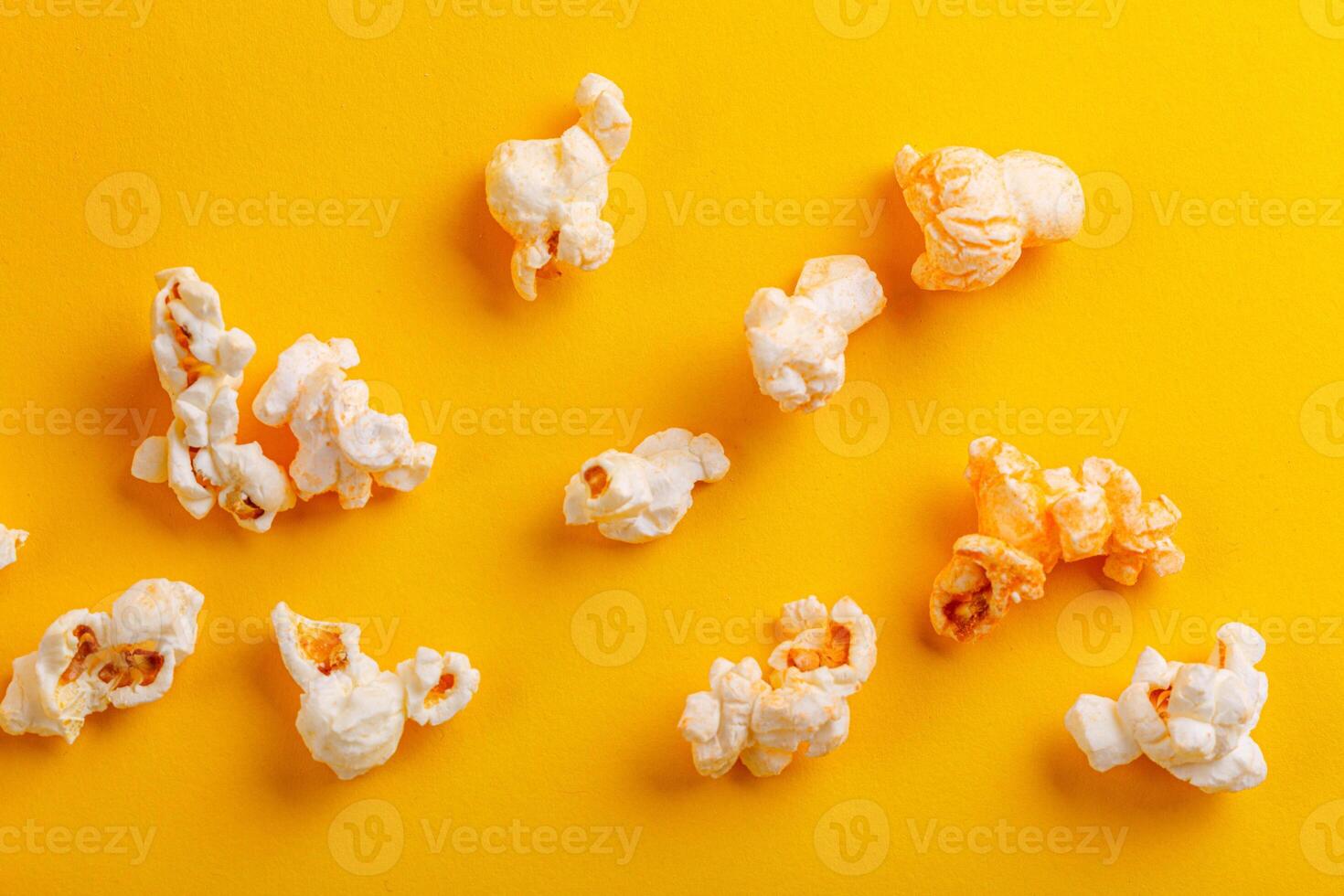 Glass with popcorn on a yellow background photo