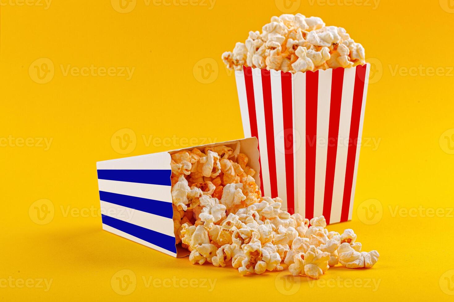Glass with popcorn on a yellow background photo