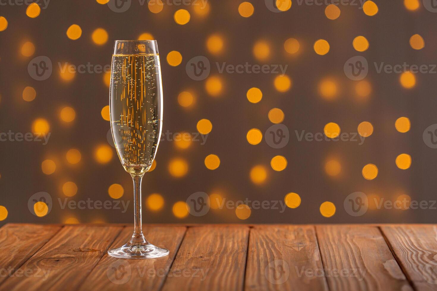 Glasses with champagne on a wooden background against a bokeh background of lights photo
