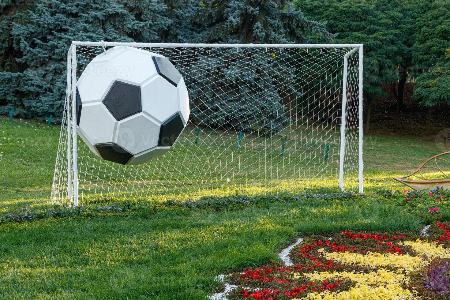 Soccer goal on grass and big ball photo