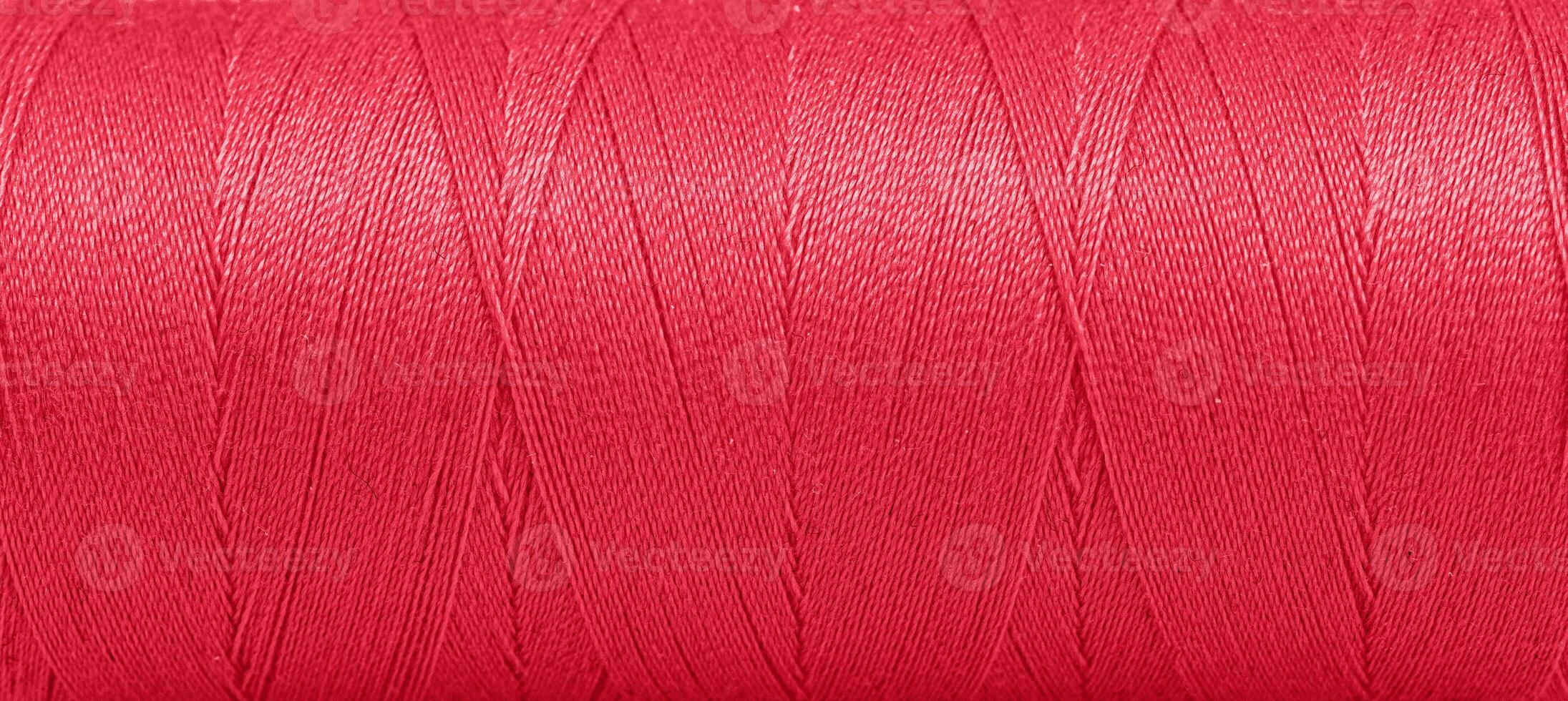 Texture of threads in a spool of red color on a white background photo