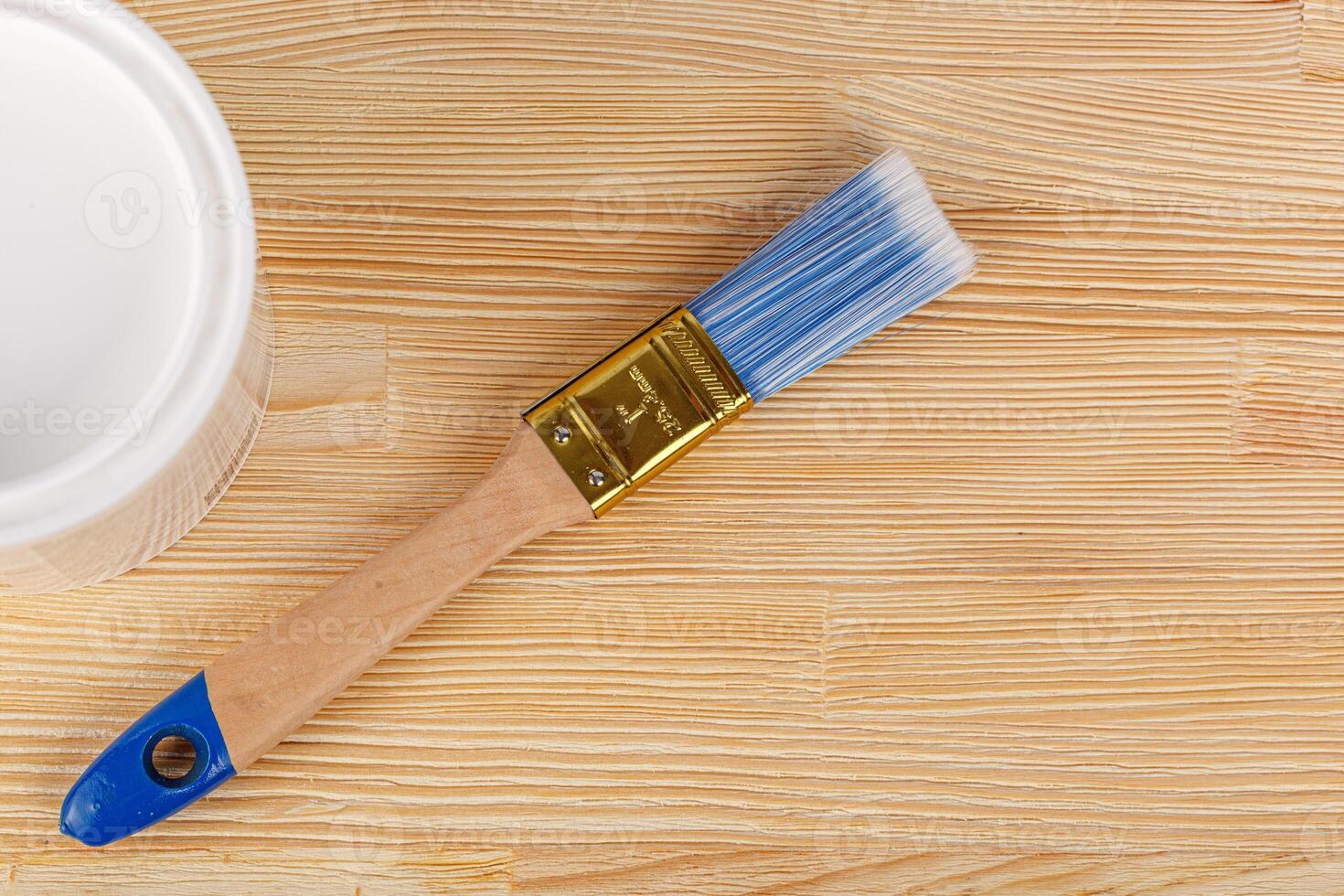 white paint with a brush on a wooden background with texture photo