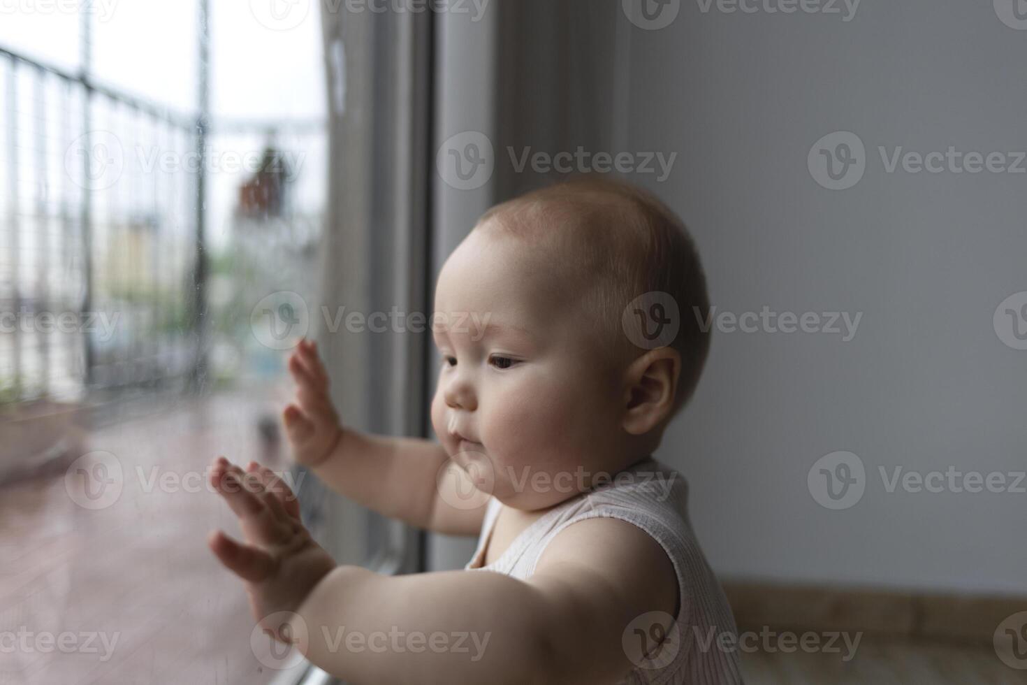 A curious baby exploring the world through a window, full of wonder and innocence photo