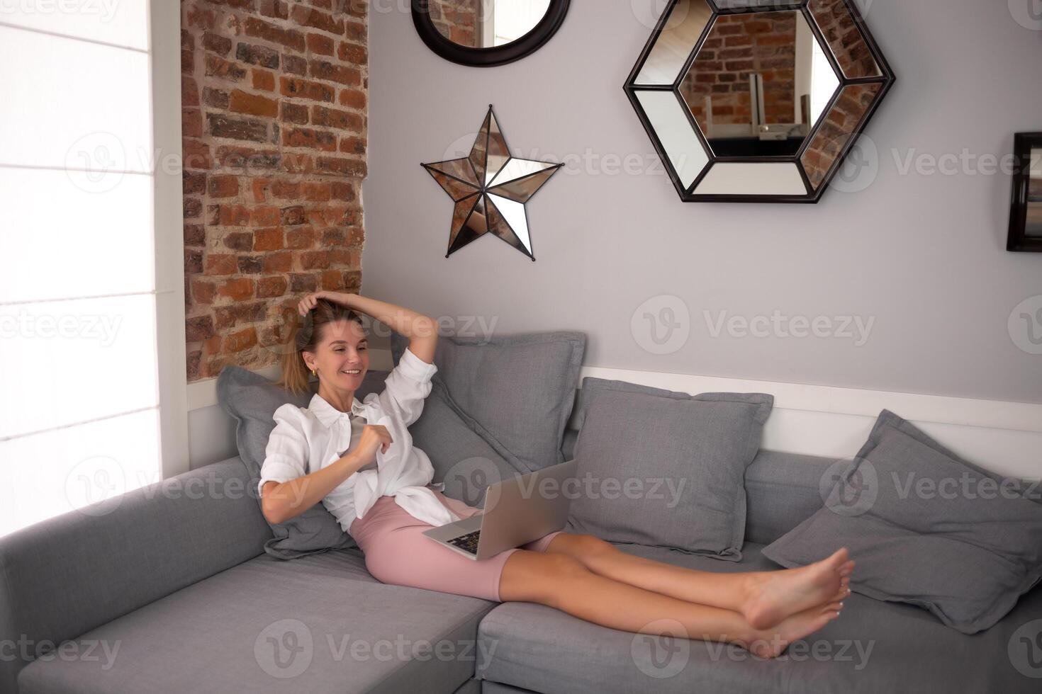 young beautiful woman working on a laptop in the living room in the apartment photo