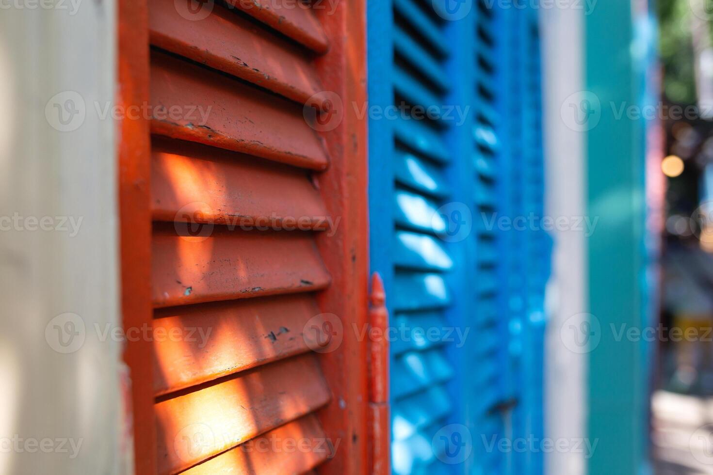 beautiful bright colorful and authentic red and blue shutters of ancient houses photo