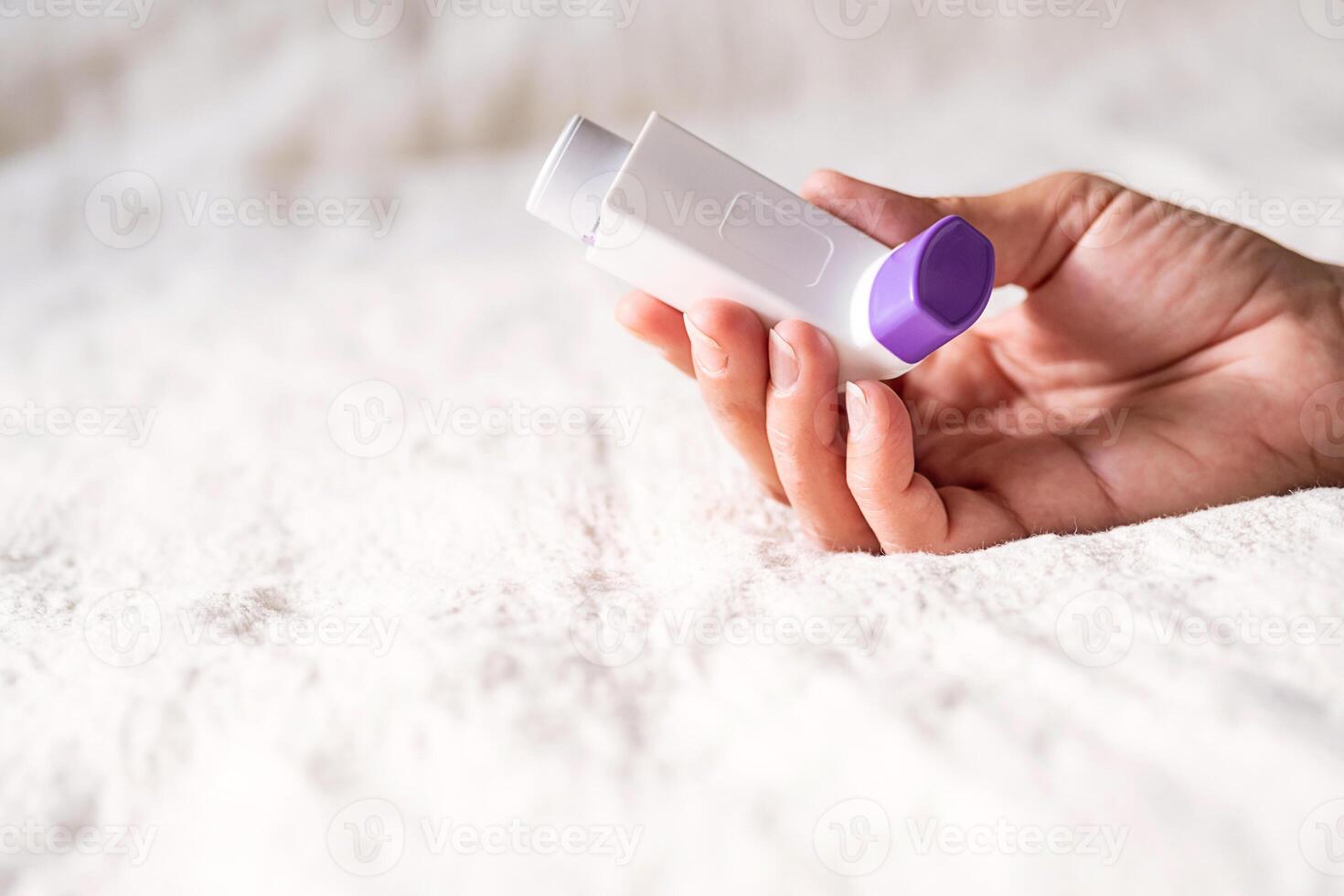 Females hand holding inhaler for asthmatics. photo