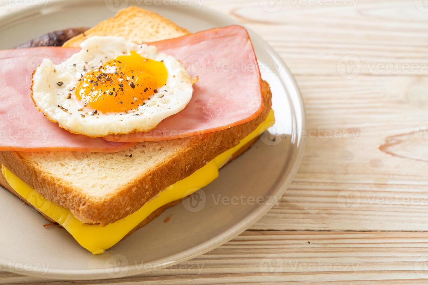 bread toasted cheese topped ham and fried egg with pork sausage photo