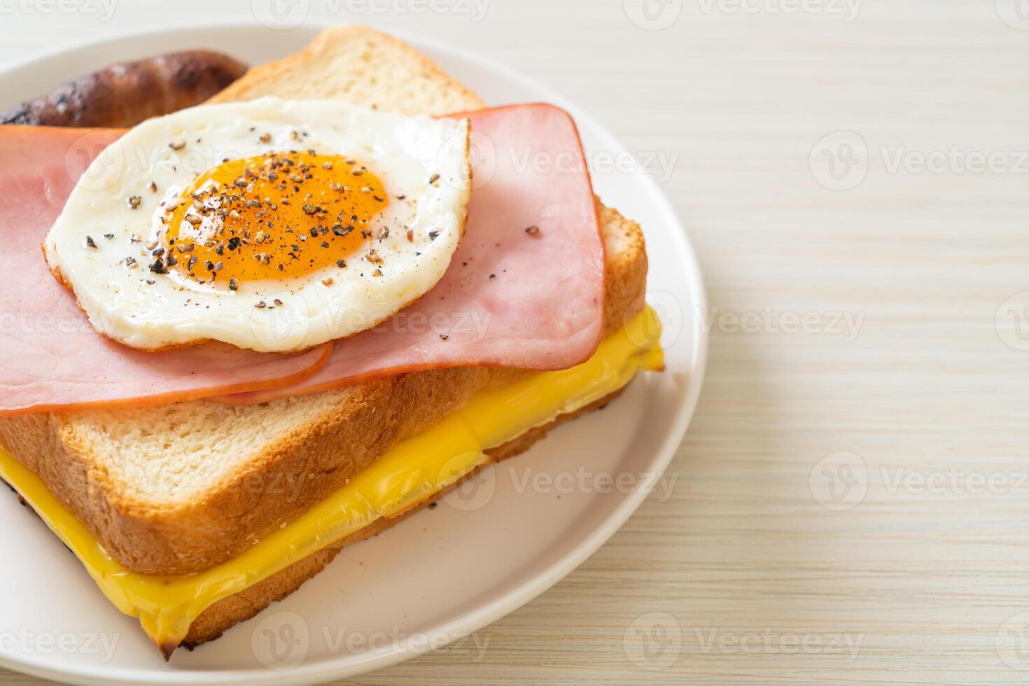 bread toasted cheese topped ham and fried egg with pork sausage photo