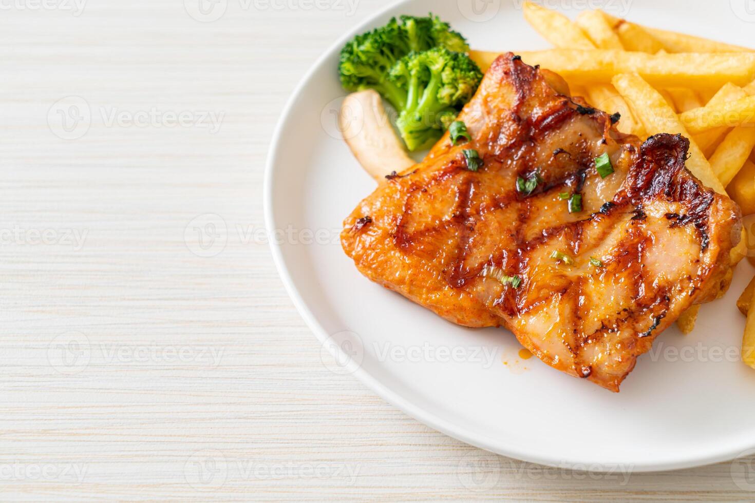 grilled chicken steak with potato chips or french fries photo