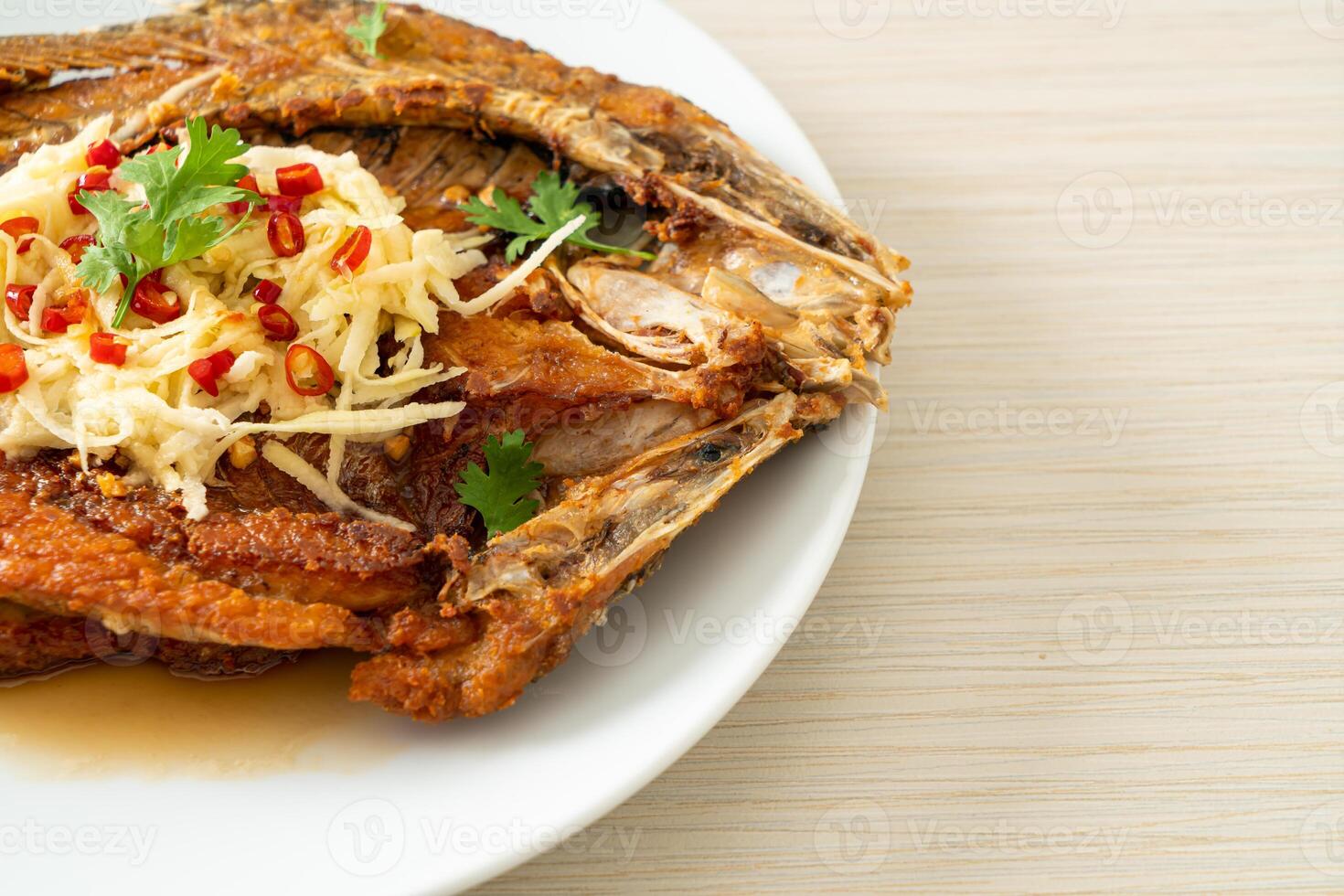Fried Sea Bass Fish with Fish Sauce and Spicy Salad photo