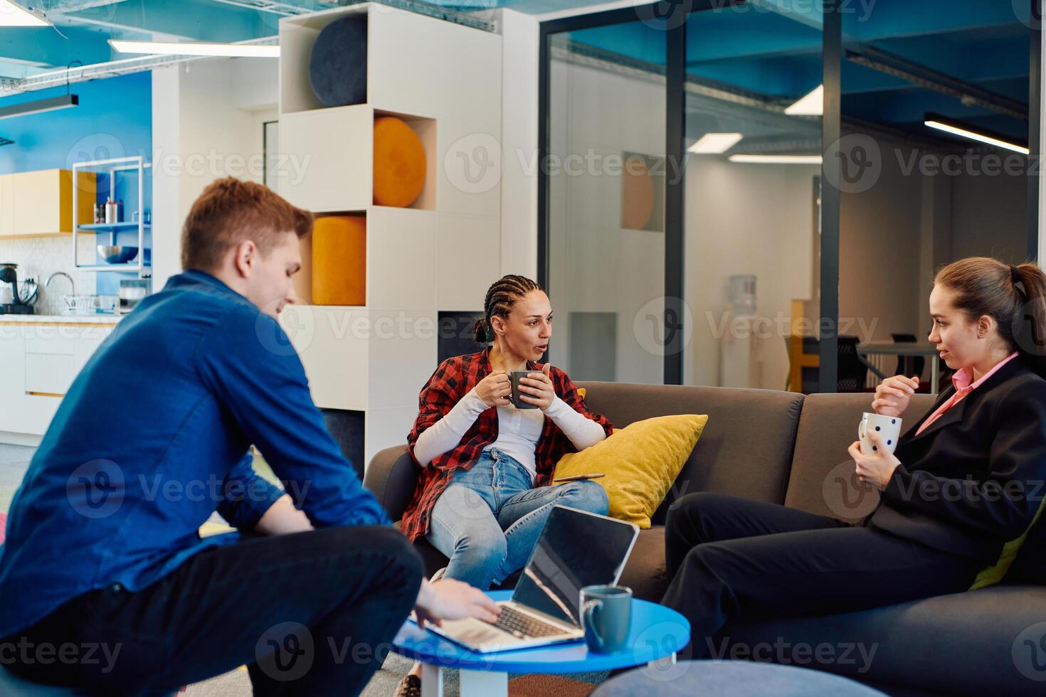 Multiethnic startup business team on meeting in a modern bright open space coworking office. Brainstorming, working on laptop. Group of coworkers walking around in motion blur photo