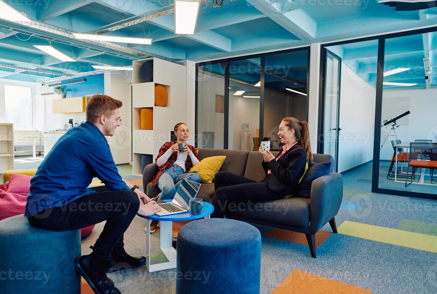 Multiethnic startup business team on meeting in a modern bright open space coworking office. Brainstorming, working on laptop. Group of coworkers walking around in motion blur photo